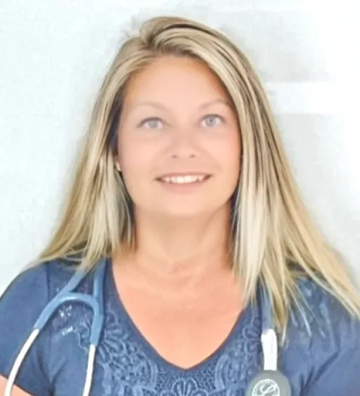 sherry-1 Smiling woman with long blonde hair, wearing a blue shirt and stethoscope around her neck.